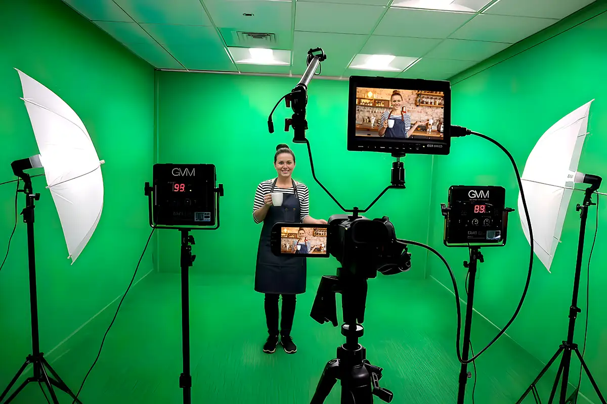Wide shot of the green-screen studio cyclorama, with broadcast lighting grid above
